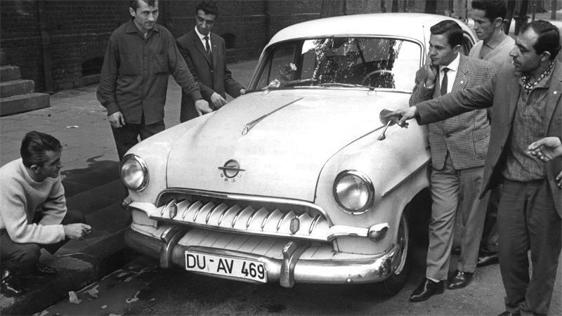 Abenteuer Almanya - Als die ersten Türken kamen Türkische „Gastarbeiter“ bewundern 1962 im Ruhrgebiet den Wagen eines Landsmanns (Archivbild).