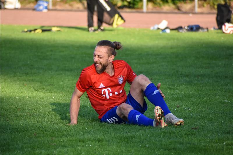 Ahmed Rahdi im roten Bayern-Heimtrikot liegt am Boden und hält sich das Knie.