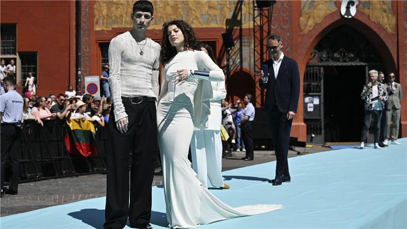 Tynna zeigt sich in einer Art Brautkleid auf dem türkisen Teppich.