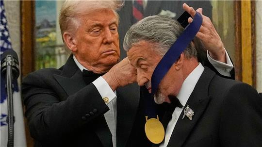 US-Präsident Donald Trump hängt der Actionfilm-Ikone Sylvester Stallone eine Medaille um. 