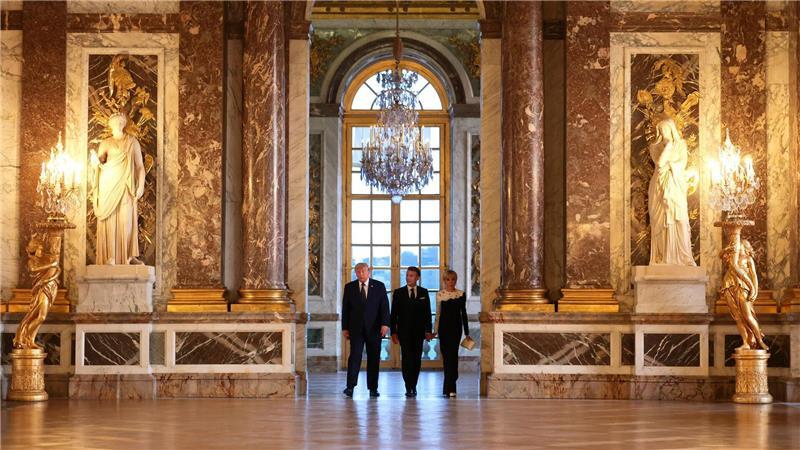 US-Präsident Donald Trump (l) wird vor einem gemeinsamen Abendessen vom französischen Präsidenten Emmanuel Macron und dessen Ehefrau Brigitte Macron durch das Schloss Versailles geführt. 