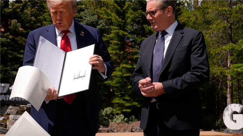 US-Präsident Donald Trump lässt Papiere fallen, als er am Rande des G7-Gipfels mit dem britischen Premierminister Keir Starmer zusammentrifft.
