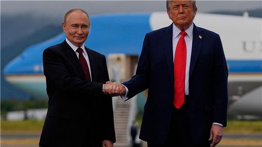 US-Präsident Donald Trump (r) und der russische Präsident Wladimir Putin geben sich auf dem Militärstützpunkt Joint Base Elmendorf-Richardson (in Alaska) die Hand.
