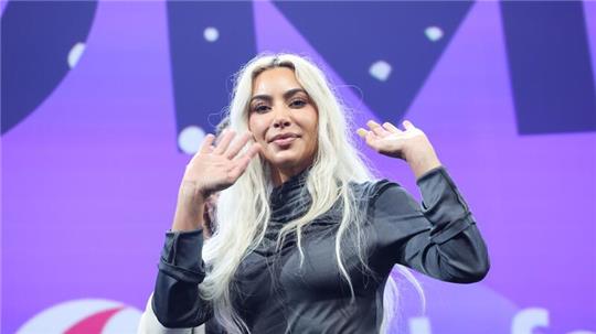 US-Superstar Kim Kardashian winkt auf der Bühne auf der Digital- und Marketingmesse OMR.