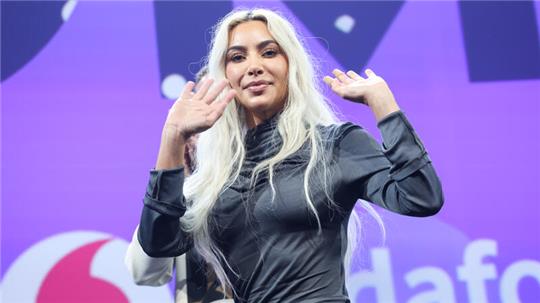 US-Superstar Kim Kardashian winkt auf der Bühne auf der Digital- und Marketingmesse OMR.