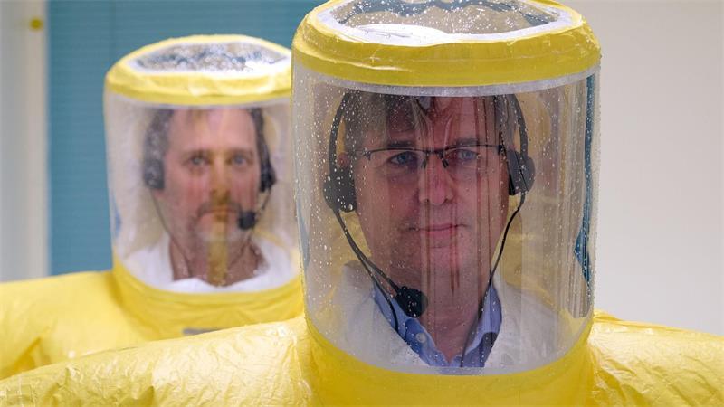 Wie Ebola-Patienten auf Isolierstationen behandelt werden Über Funk bekommen die Ärzte wie Björn Jensen (rechts) Anweisungen, wie genau sie die Anzüge mit Säure abduschen müssen. (Archivbild)