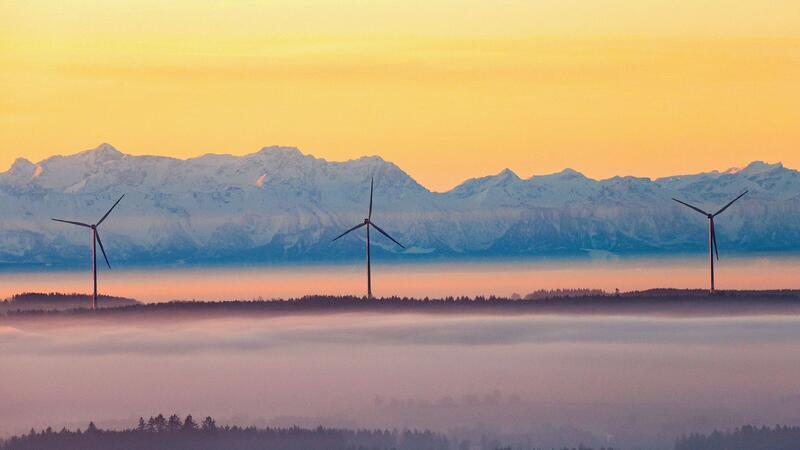 Bilder des Tages Über einhundert Kilometer sind die Alpen entfernt, aber durch den Föhn werden die Berge optisch ganz nah an die Windräder gerückt, die sich aus der Nebeldecke herausschälen.