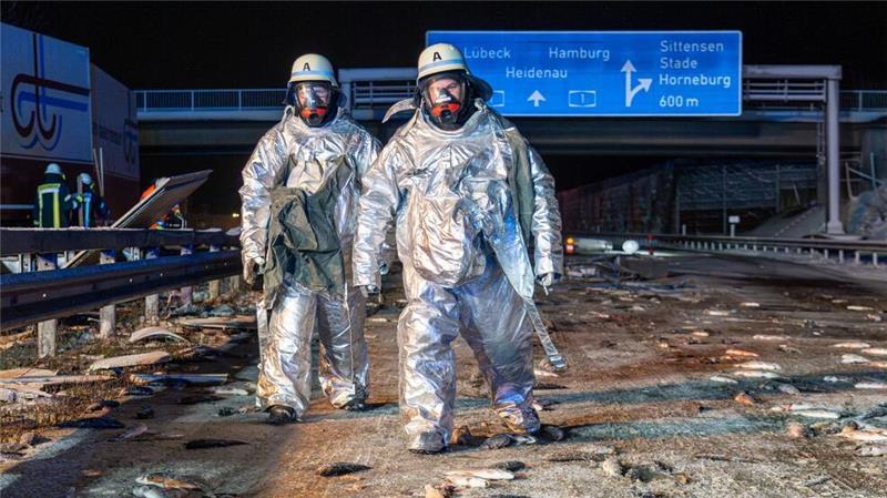 Gefährliche Glätte in ganz Deutschland Überall Fische auf der Fahrbahn: Bei dem Unfall auf der A1 mussten Feuerwehrleute die Unfallstelle zunächst in speziellen Schutzanzügen sichern.