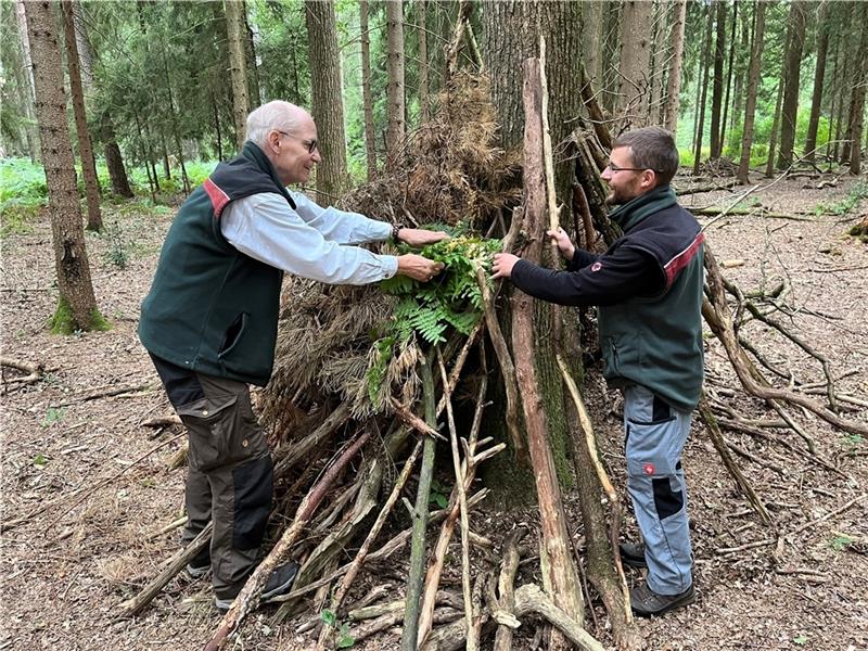 Überlebenstraining: Die Waldpädagogen Jörn Freyenhagen und Jonas Maiwald bauen ein „Tipi“ im Rüstjer Forst (von links). Foto Vasel