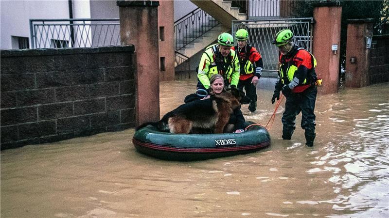 Überschwemmungen nach Unwettern im Norden Italiens: Eine Frau wird mit ihrem Hund von Rettungskräften in einem Schlauchboot evakuiert.