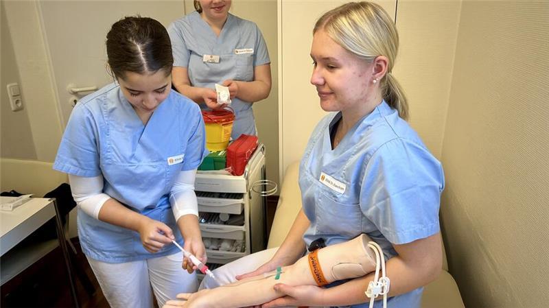 Klinik Dr. Hancken in Stade stellt Ausbildungsberufe vor Übung beim Azubi-Infotag: Lara Kaouach, Lilli Krause und Emily Wist nehmen Blut am Trainingsarm ab.