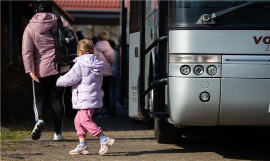 Ukrainische Flüchtlinge steigen an der Flüchtlingsunterkunft aus einem Bus.