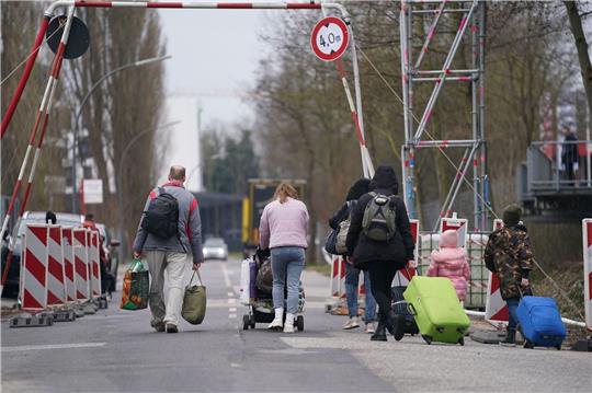 Ukrainische Flüchtlinge verlassen mit ihrem Gepäck die Flüchtlingsunterkunft in Hamburg.