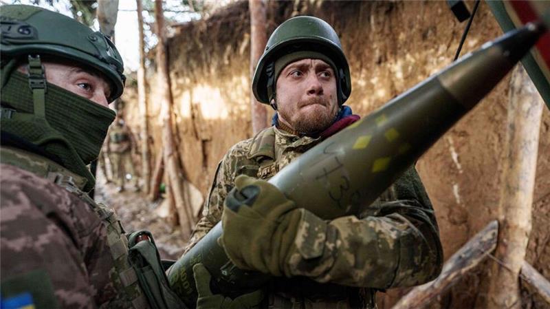 Ukrainische Soldaten der 26. Artilleriebrigade laden in der Region Donezk Munition in eine Panzerhaubitze.