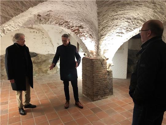 Ulf Brokelmann (Mitte) erklärt Dr. Volker Drecktrah von der Denkmalschutz-Stiftung (links) und Bürgermeister Sönke Hartlef den Zustand des Kellergewölbes. Foto: Strüning