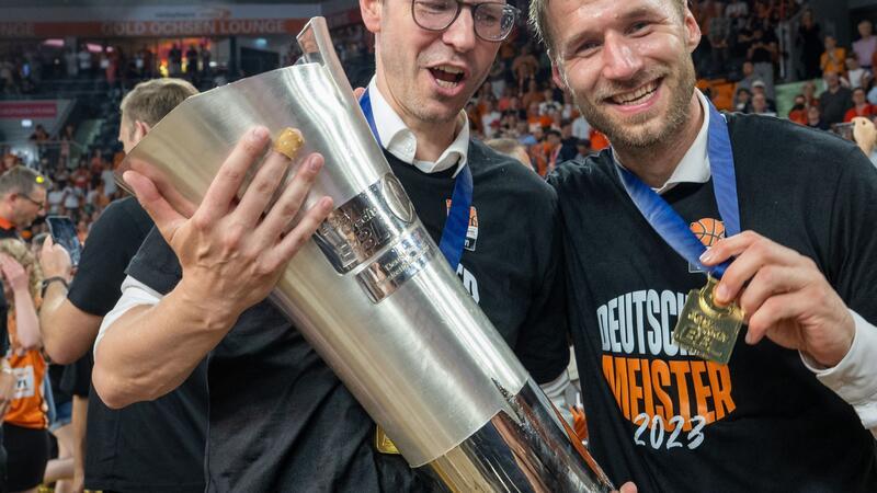 Ulms Trainer Anton Gavel (r) und Sportdirektor Thorsten Leibenath halten den Meisterpokal.