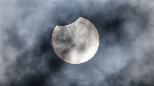 Um 11.21 Uhr verdeckt der Mond einen kleinen Teil der Sonne über Köln. Foto: Christoph Reichwein/dpa