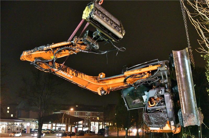 Um 19 Uhr hängt der gesunkene Bagger am Haken des Krans: Rund acht Stunden zuvor war das Gefährt bei Mäharbeiten am Hang gegenüber des Autohauses Spreckelsen in den Burggraben gerutscht. Foto Beneke