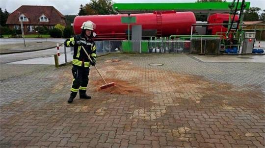 Um eine Gewässerverunreinigung zu verhindern, dichten die Feuerwehrleute umgehend einen angrenzenden Gully ab, damit kein Kraftstoff in die Kanalisation gelangen kann.