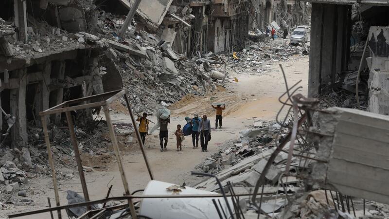 Israel: Heftige Kontroverse über Zukunft Gazas Umgeben von Trümmern gehen diese Palästinenser durch das zerstörte Chan Junis.