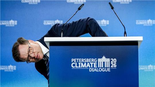 Umweltminister Carsten Schneider (SPD) beugt sich beim 17. Petersberger Klimadialog neben das Pult.