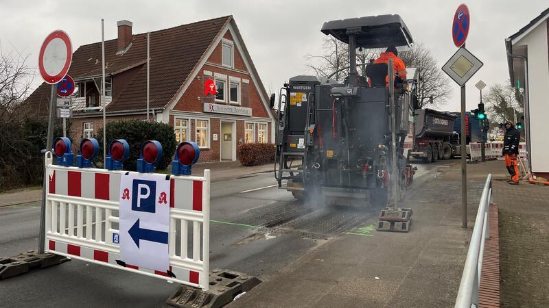 Pendler können aufatmen: Ein Ende der Vollsperrung in Neuenfelde ist in Sicht Unablässig zertrümmern die rotierenden stählernen Meißel einer Fräse den Asphalt auf der Kreuzung Nincop in Hamburg-Neuenfelde.