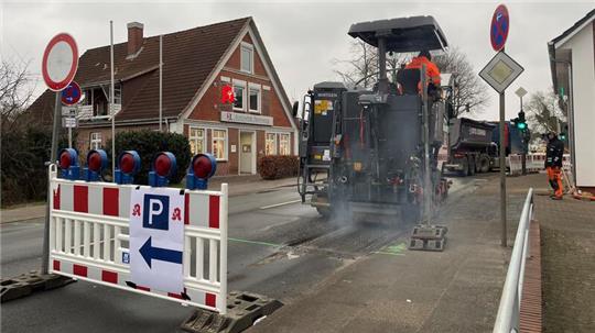 Unablässig zertrümmern die rotierenden stählernen Meißel einer Fräse den Asphalt auf der Kreuzung Nincop in Hamburg-Neuenfelde.