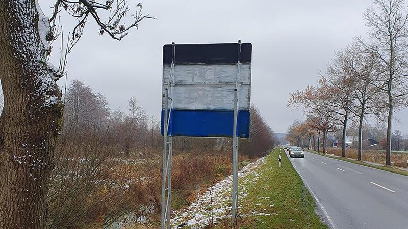 Unbekannte haben ein Schild mit Farbe besprüht.