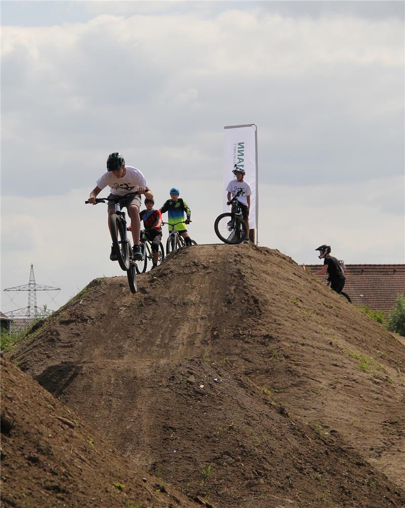 Und ab geht‘s: Lars Borgmann testet den Bikepark Altes Land. Gemeinsam mit seinem Freund Kilian Rokitta (hinten rechts) hatte er die Idee für den Fahrradparcours. Foto Meybohm