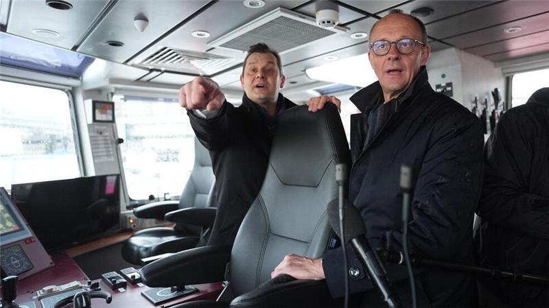 Unionskanzlerkandidat Friedrich Merz lässt sich vom Inhaber des Hamburger Unternehmens VB Group beim Besuch des Feuerlöschboots „Prag“ den Hamburger Hafen zeigen.