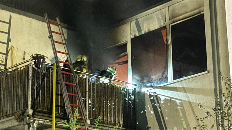 Unter Atemschutz rückten Feuerwehrleute über den Balkon in die brennende Wohnung vor.
