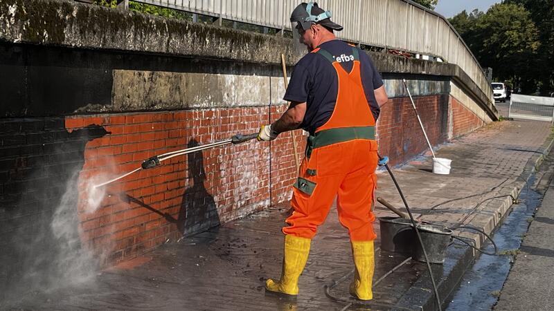 Unter Dampf: Bernd Elkereit richtet den Heißwasserstrahl aus dem Hochdruckreiniger auf die Wand.
