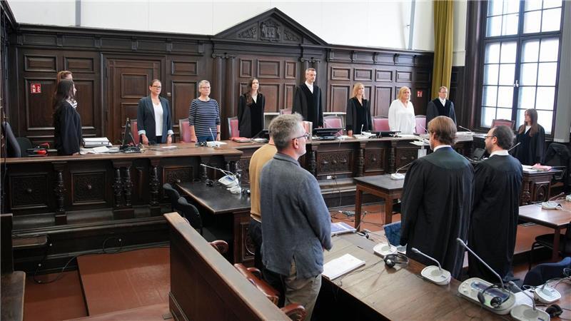 Prozess gegen möglichen Kokainschmuggler hat begonnen Unter anderem der Angeklagte, verdeckt im bräunlichen Shirt, hat sich erhoben.