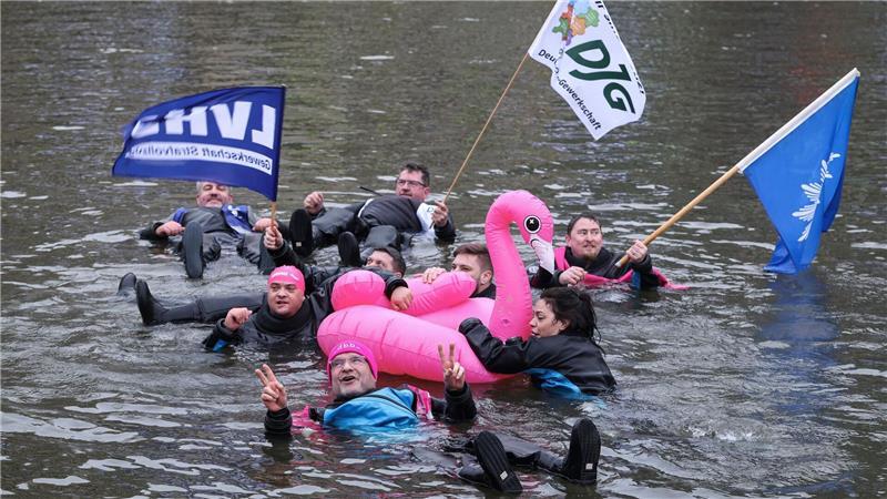 Unter dem Motto „Wir gehen baden, damit der Norden nicht absäuft“ schwimmen Teilnehmer beim Warnstreik im öffentlichen Dienst in Hamburg. 