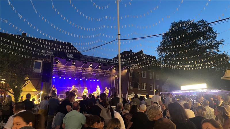 Unter dem weißen Fahnendach auf dem Petri-Platz sind die Leute beim Buxtehuder Altstadtfest bester Stimmung.