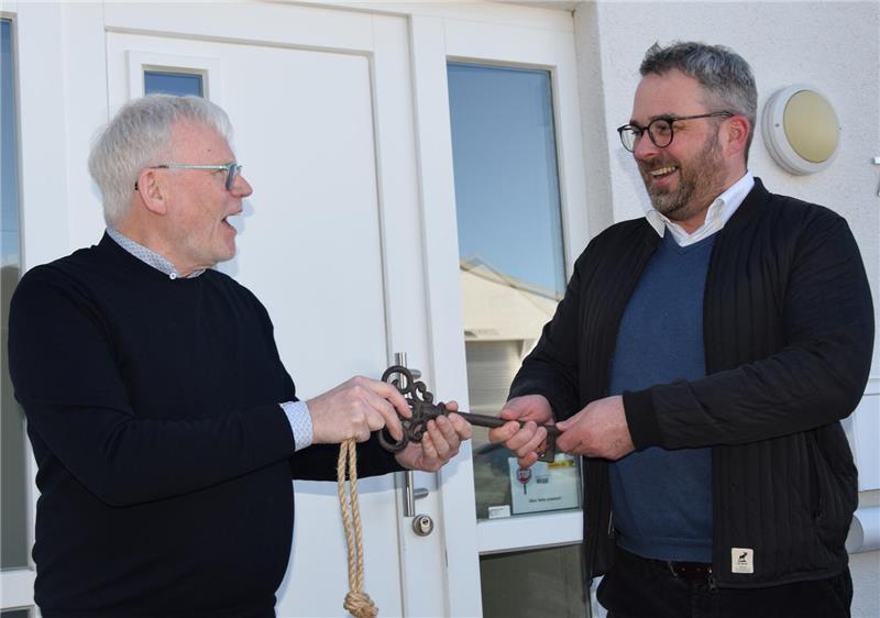 Vier neue Gesellschafter: Buxtehuder Bio-Pionier gelingt die Nachfolge Unternehmensnachfolge bei Keimling Naturkost gelungen: Firmengründer Winfried Holler (links) übergibt vor dem Eingang des Verwaltungsgebäudes einen symbolischen Schlüssel an den neuen Geschäftsführer Tim-Oliver Horn.