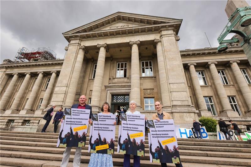 Unterstützer der Volksinitiative «Hamburg soll Grundeinkommen testen!» stehen vor dem Oberlandesgericht.