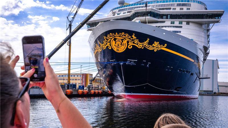 Bilder des Tages Urlauber fotografieren bei einer Hafenrundfahrt das neue Kreuzfahrtschiff „Disney Adventure“ am Ausrüstungskai der Wismarer Werft.