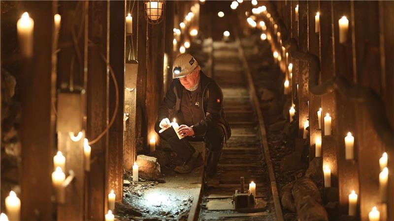 Uwe Reisner vom Förderverein Rabensteiner Stollen zündet im Stollen Kerzen an. 