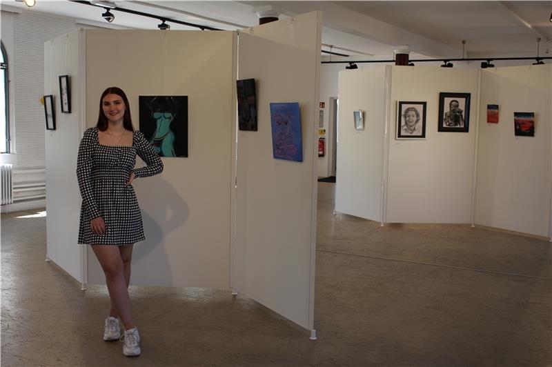 Vanessa Spors hat die Ausstellung im Deck 1 entwickelt. Auch sie zeichnet und malt, die drei hinter ihr hängenden Bilder sind von ihr. Foto: Frank