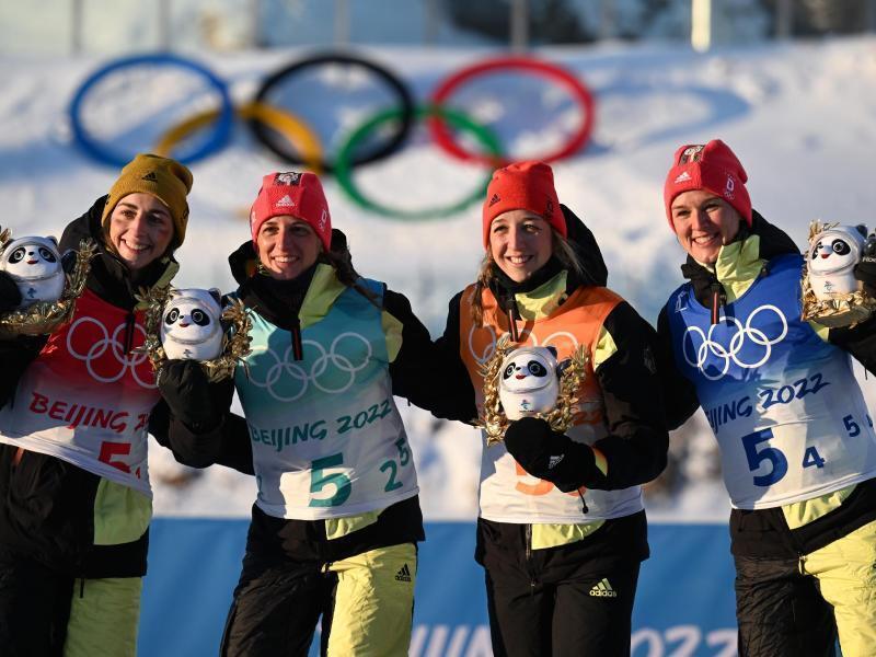 Vanessa Voigt (l-r), Vanessa Hinz, Franziska Preuss und Denise Herrmann freuen bei der Flower Ceremony über olympisches Bronze. Foto: Hendrik Schmidt/dpa-Zentralbild/dpa