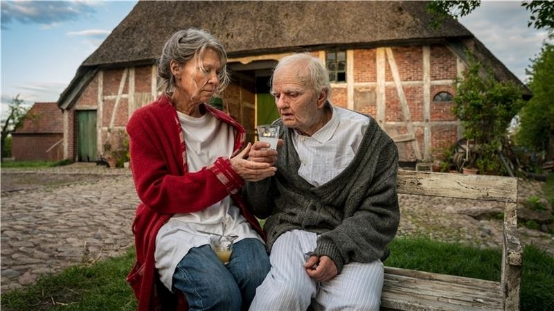 Vera Eckhoff (Iris Berben) erfüllt ihrem Stiefvater Karl (Milan Peschel) auf der weißen Bank vor dem Haus einen langgehegten Wunsch. Foto: ZDF/Pauly