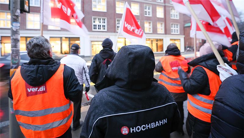 Verdi-Mitgliedern der Hamburger Hochbahn stehen bei einer Kundgebung vor dem Hochbahnhaus in der Steinstraße. Foto: Christian Charisius/dpa