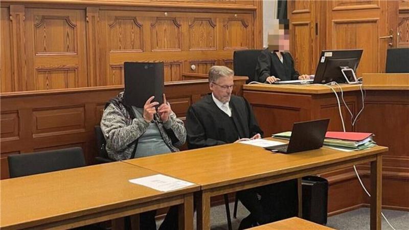 Mordprozess in Stade: Wer war Ursula B.? Verhandlungsauftakt vor der 3. Großen Strafkammer: Im Gerichtssaal verbirgt der neben seinem Anwalt sitzende Angeklagte sein Gesicht hinter einem Aktendeckel.