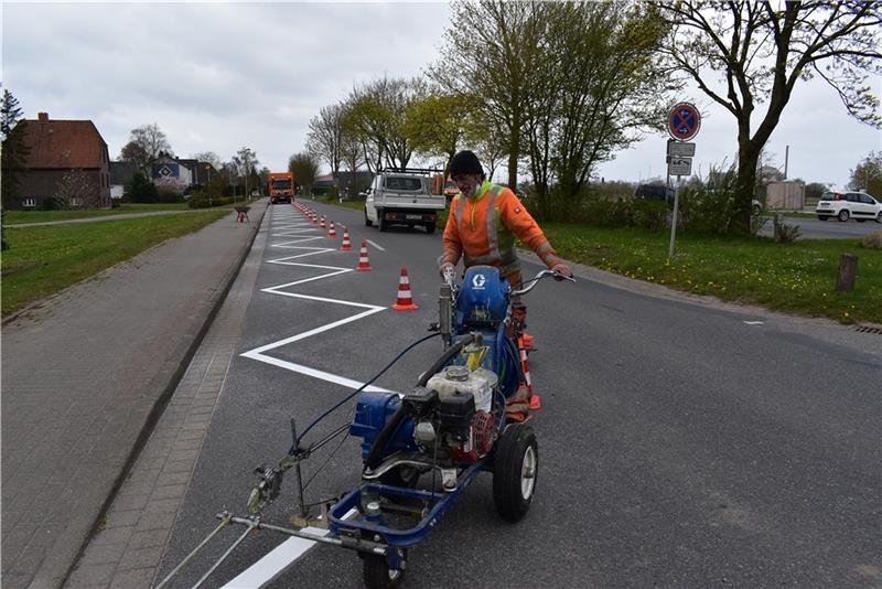 Verkehrschaos verhindern: Luis Francisco von der FMT Fahrbahnmarkierungstechnik GmbH aus Hamburg bringt in dieser Woche mit seiner Maschine die Grenzmarkierung auf die Kreisstraße 34 in Bassenfleth auf. Foto: Vasel