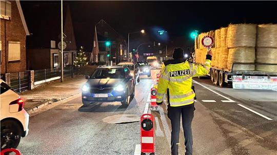 Ein Polizist winkt Autos aus.