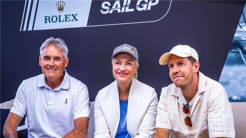 Gekommen um zu bleiben: SailGP verlängert um zwei Jahre Verkündeten, dass die SailGP wieder nach Deutschland kommt: SailGP-Gründer Russell Coutts, Mecklenburgs Ministerpräsidentin Manuela Schwesig und der viermalige Formel-1-Weltmeister Sebastian Vettel.