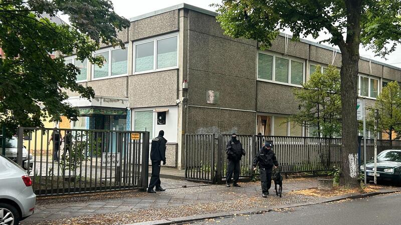 Nach Vereinsverbot: Iran bestellt deutschen Botschafter ein Vermummte Polizisten stehen an einem Gebäude, in dem sich das Islamische Zentrum Berlin befindet.