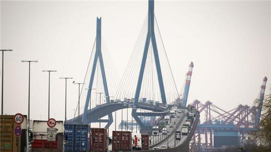 Verschiedene Fahrzeuge, LKW und Containertransporter fahren über die Köhlbrandbrücke im Hamburger Hafen.