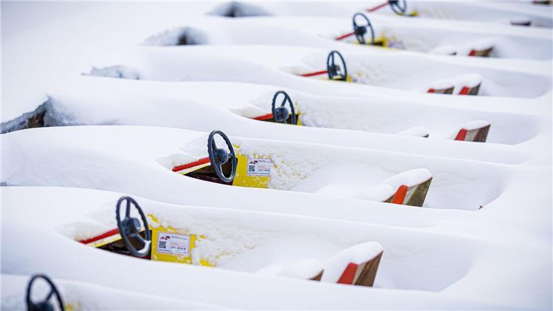 Verschneite Tretboote liegen im zugefrorenen Maschsee